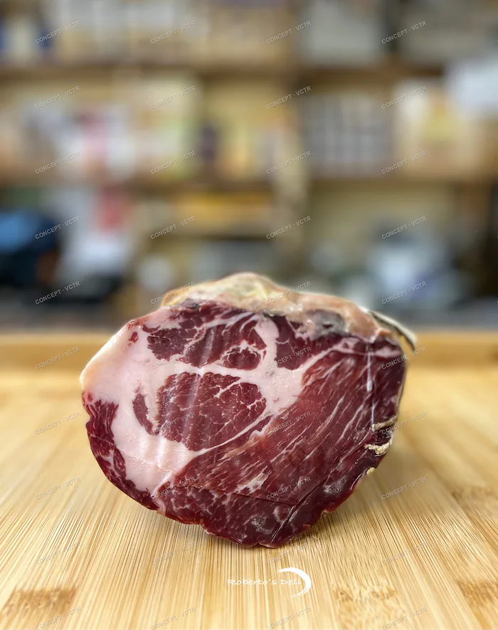 A whole coppa on a wooden board